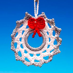 Couronne de Noël blanche et bord argenté avec nœud rouge