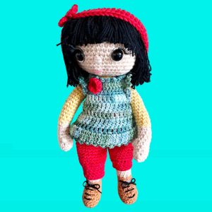 Poupée au gilet bleu, pantalon et bandeau rouge